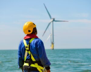 Man,And,Standing,At,An,Offshore,And,Wind,Turbine.